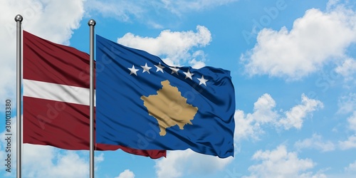 Latvia and Kosovo flag waving in the wind against white cloudy blue sky together. Diplomacy concept, international relations.