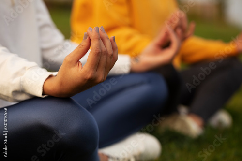 two girls doing yoga, girls sitting on the grass