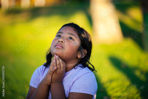 Εκτύπωση καμβά A latino girl with strong conviction towards God, kneels to pray in supplication to the most high God