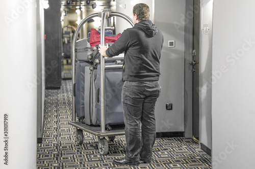 Many suitcases on hotel luggage cart moving by bell boy. Baggage porter or bell boy bringing the suitcase of guests with a box van to the hotel room. Trolley Luggage at the hotel.  © polack