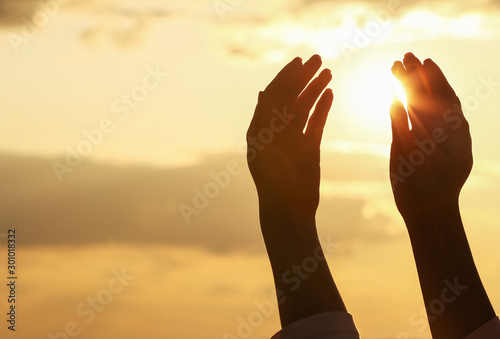 Canvas Print Hands of Muslim woman praying outdoors at sunset
