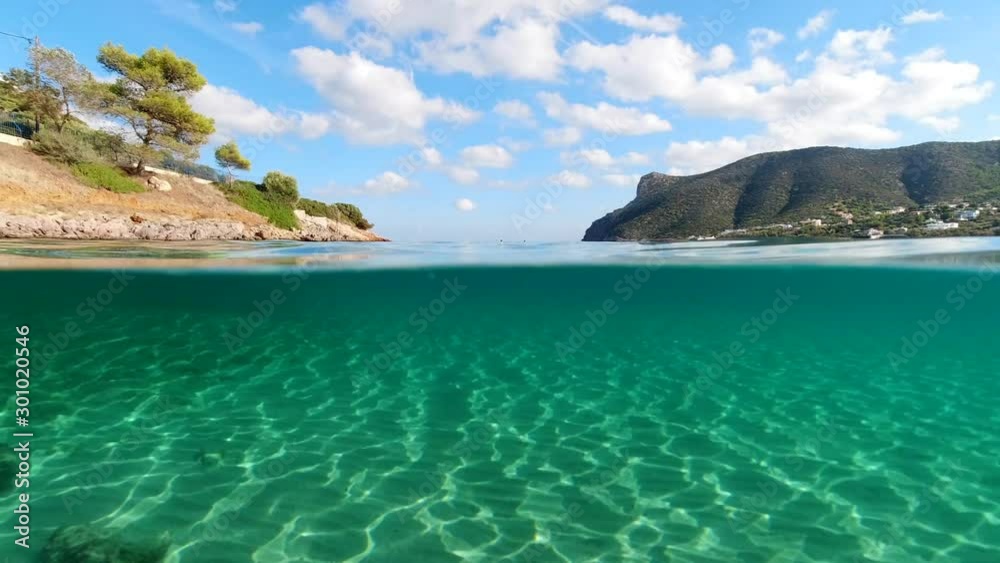 Above and below underwater video of tropical exotic turquoise sandy beach in Caribbean secluded destination with deep blue sky and clouds Above and below underwater video of tropical exotic turquoise sandy beach in Caribbean secluded destination with deep blue sky and clouds