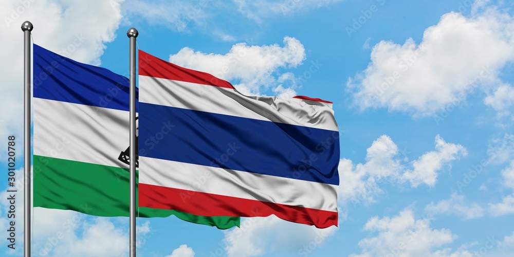 Lesotho and Thailand flag waving in the wind against white cloudy blue sky together. Diplomacy concept, international relations.