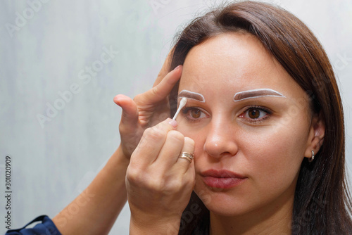 The wizard creates the contour of the clients eyebrows before the procedure.