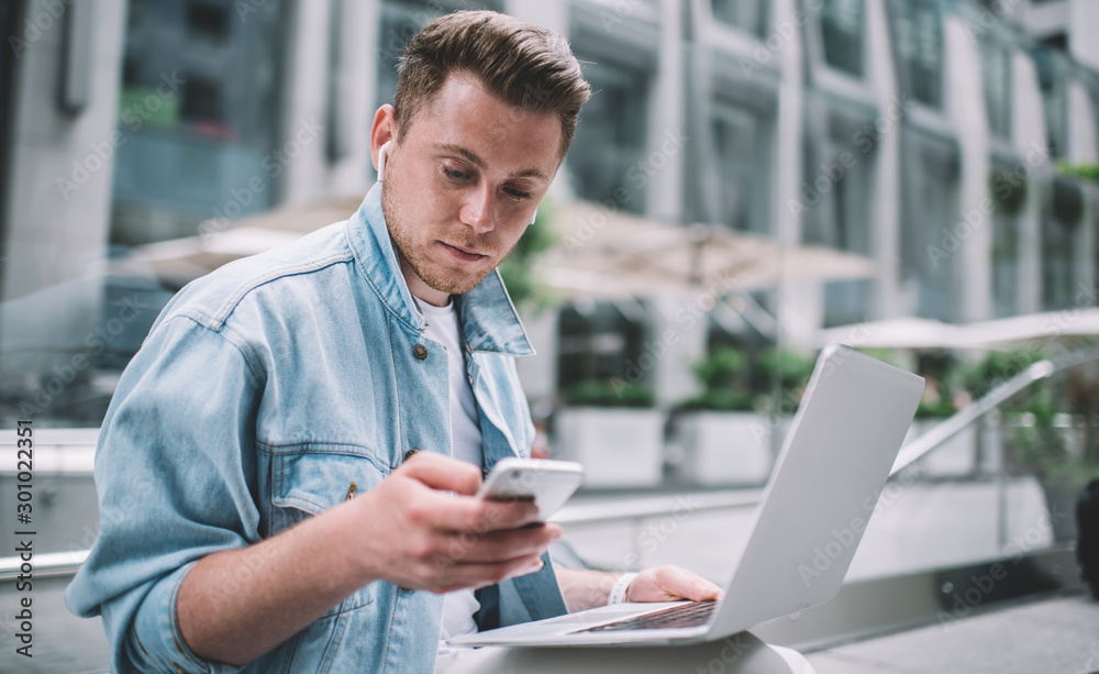 Modern man with gadgets sitting on street Modern man with gadgets sitting on street