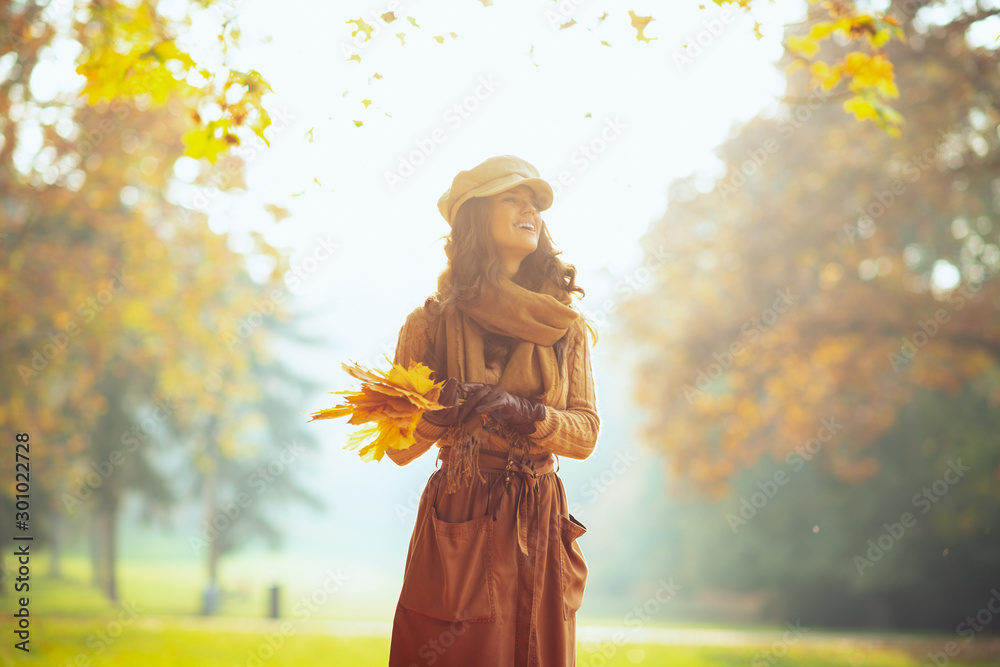smiling woman with yellow leaves outdoors in autumn park