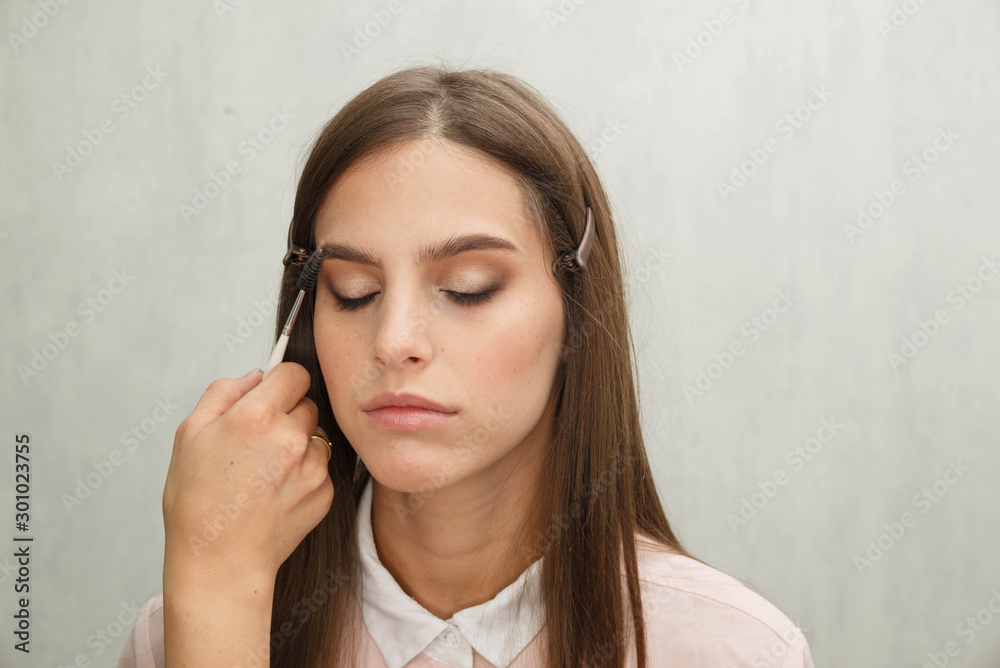 Makeup artist creates eyeliner on the face of the model. Makeup artist creates eyeliner on the face of the model.