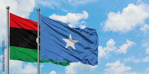 Libya and Somalia flag waving in the wind against white cloudy blue sky together. Diplomacy concept, international relations.