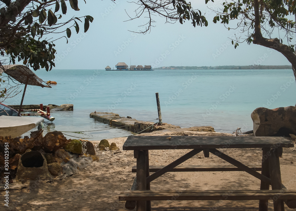 Vista al mar desde la playa con un banco de madera y un muelle Stock Photo  | Adobe Stock