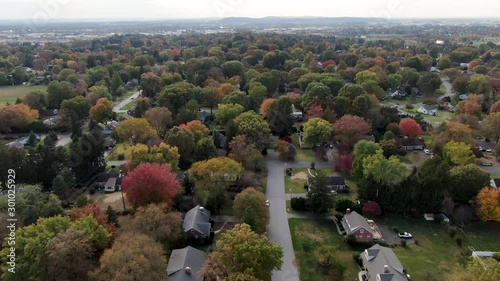 AERIAL DOLLY BACK Small Tree Filled Village During Autumn, Fall Foliage photo