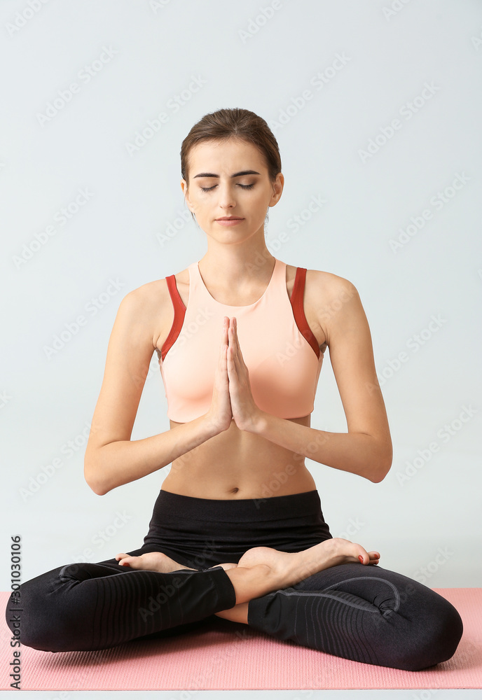 Beautiful young woman practicing yoga on light background Beautiful young woman practicing yoga on light background