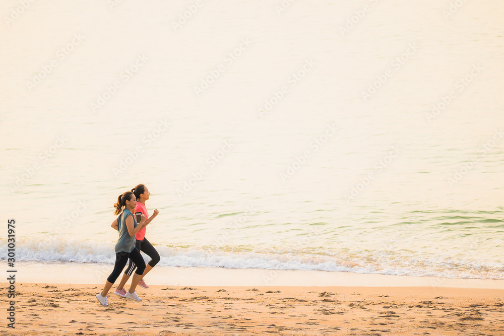 Portrait beautiful young sport asian woman running and exercise on the beach near sea and ocean at sunrise or sunset time Portrait beautiful young sport asian woman running and exercise on the beach near sea and ocean at sunrise or sunset time