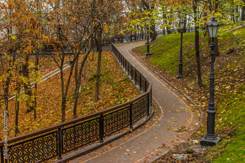 KIEV, UKRAINE - Oktober 27 2019: Autumn in Kiev park. Saint Vladimir Monument view through yellow tree foliage in Vladimir park and view of Dnieper River in urban park Volodymyrska Hill