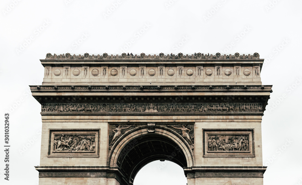 Fototapeta premium The iconic Arc the Triomphe in a blue sky day in Paris, France, Europe. Famous touristic places in Europe. European city travel concept.