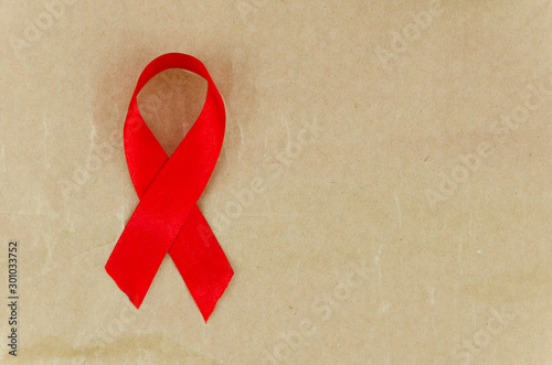 Flat lay frame mockup AIDS red ribbon on a craft background, HIV ribbon with copy space for 1st December day photo