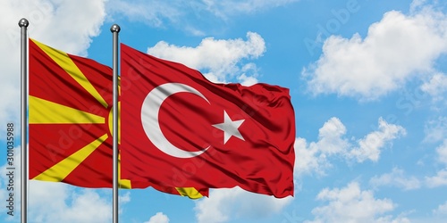 Fotografía Macedonia and Turkey flag waving in the wind against white cloudy blue sky together
