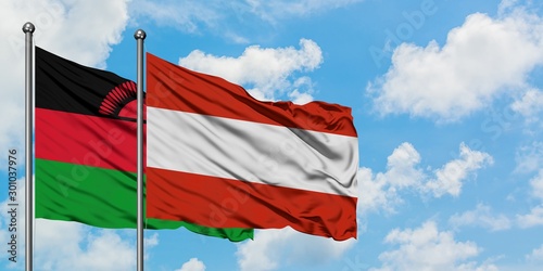 Canvas Print Malawi and Austria flag waving in the wind against white cloudy blue sky together