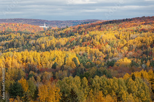 Church steeple amid autumn colorful trees in mountains