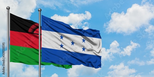 Malawi and Honduras flag waving in the wind against white cloudy blue sky together. Diplomacy concept, international relations.