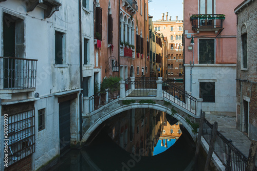View of the canals and buildings of Venice. Beautiful historic brick buildings on the narrow streets and canals of the ancient city. Warm autumn day, travel to Italy. © Evgenii Starkov