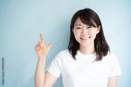Young woman explaining against light blue background