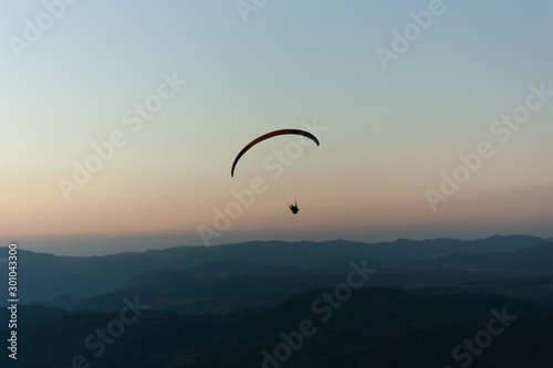 silhouette of a paraglider at sunset