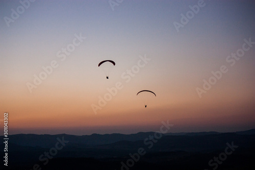 silhouette of a paraglider at sunset