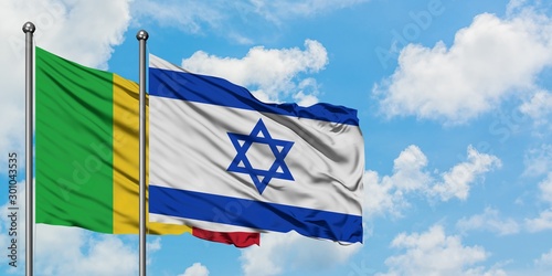 Mali and Israel flag waving in the wind against white cloudy blue sky together. Diplomacy concept, international relations.