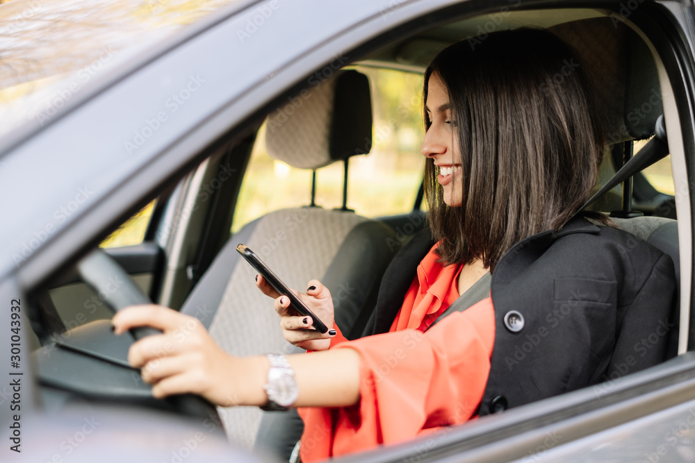 Elegant woman chatting while driving an automobile