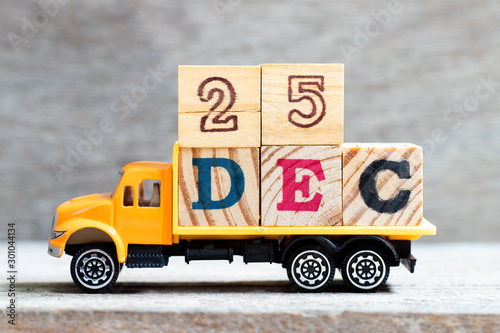 Truck hold letter block in word 25dec on wood background (Concept for date 25 month December , Christmas) photo