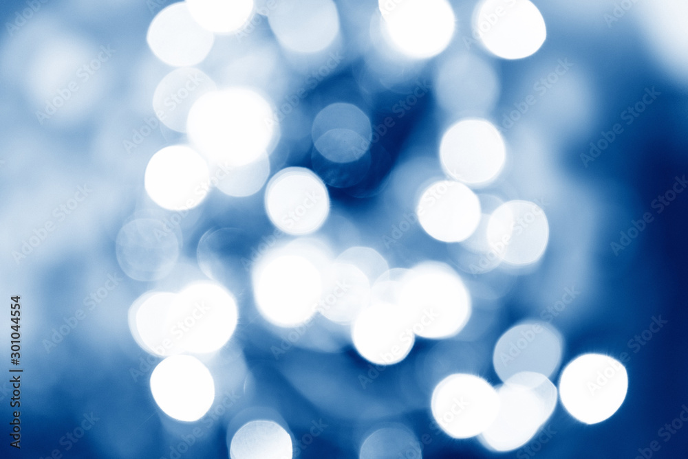 Blurred blue bokeh and lights decorated christmas tree on black background for holidays festival celebration Blurred blue bokeh and lights decorated christmas tree on black background for holidays festival celebration