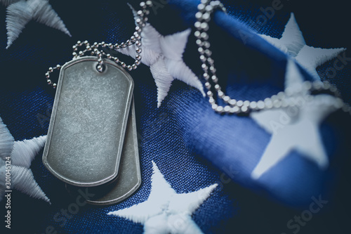 Worn USA military dog tags close up on US American flag with blank space for text
