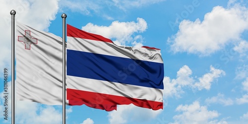 Malta and Thailand flag waving in the wind against white cloudy blue sky together. Diplomacy concept, international relations.