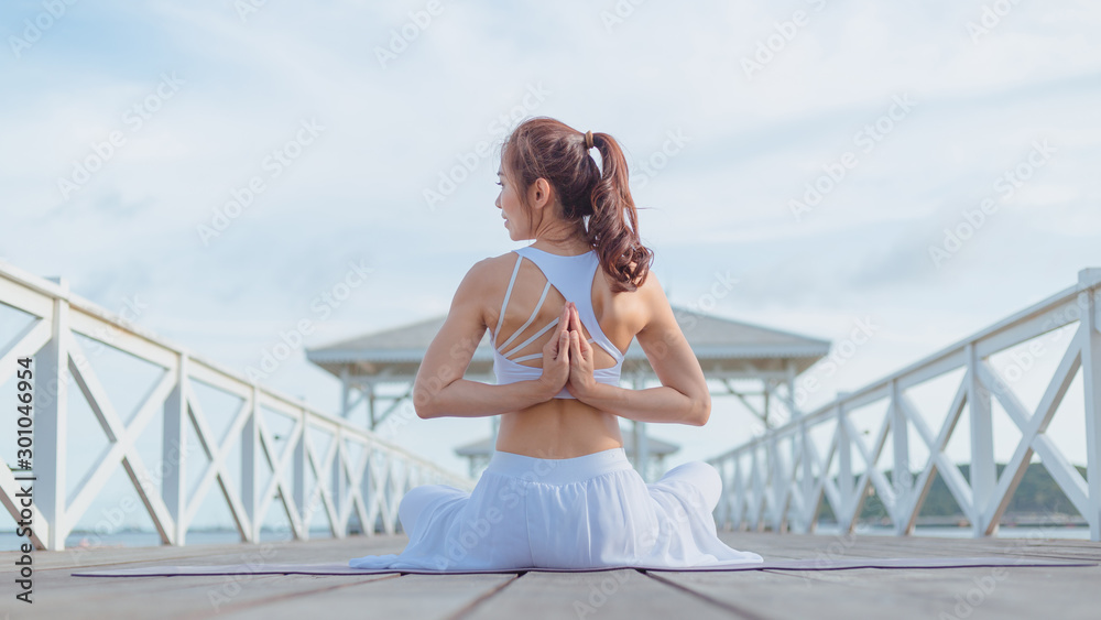Young women doing yoga, outdoor exercise in the beautiful white bridge The morning sunrise, Namaste Lotus induces meditation and relaxation. Young women doing yoga, outdoor exercise in the beautiful white bridge The morning sunrise, Namaste Lotus induces meditation and relaxation.