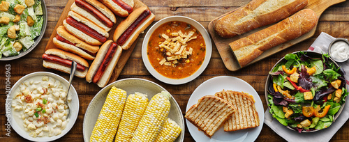 table top meal with hot dogs, grilled cheese, soup and salad in flat lay composition photo