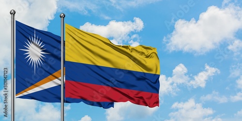 Marshall Islands and Colombia flag waving in the wind against white cloudy blue sky together. Diplomacy concept, international relations.