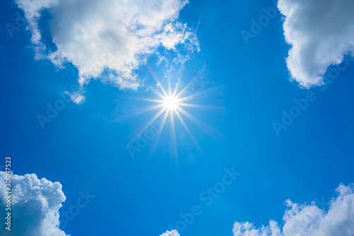 blue sky with clouds and sun reflection.The sun shines bright in the daytime in summer.