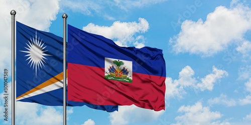 Marshall Islands and Haiti flag waving in the wind against white cloudy blue sky together. Diplomacy concept, international relations.