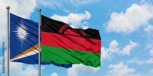 Marshall Islands and Malawi flag waving in the wind against white cloudy blue sky together. Diplomacy concept, international relations.