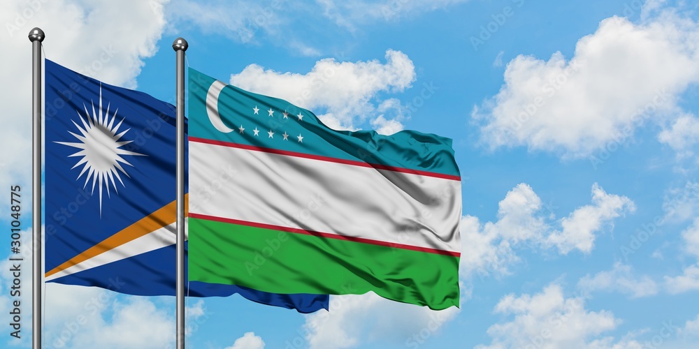 Marshall Islands and Uzbekistan flag waving in the wind against white cloudy blue sky together. Diplomacy concept, international relations.