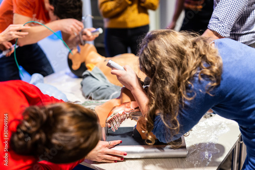 Medical doctor expert instructor displaying method of patient intubation on medical education training and workshop. Participants working in teams learning new medical procedures and techniques. photo