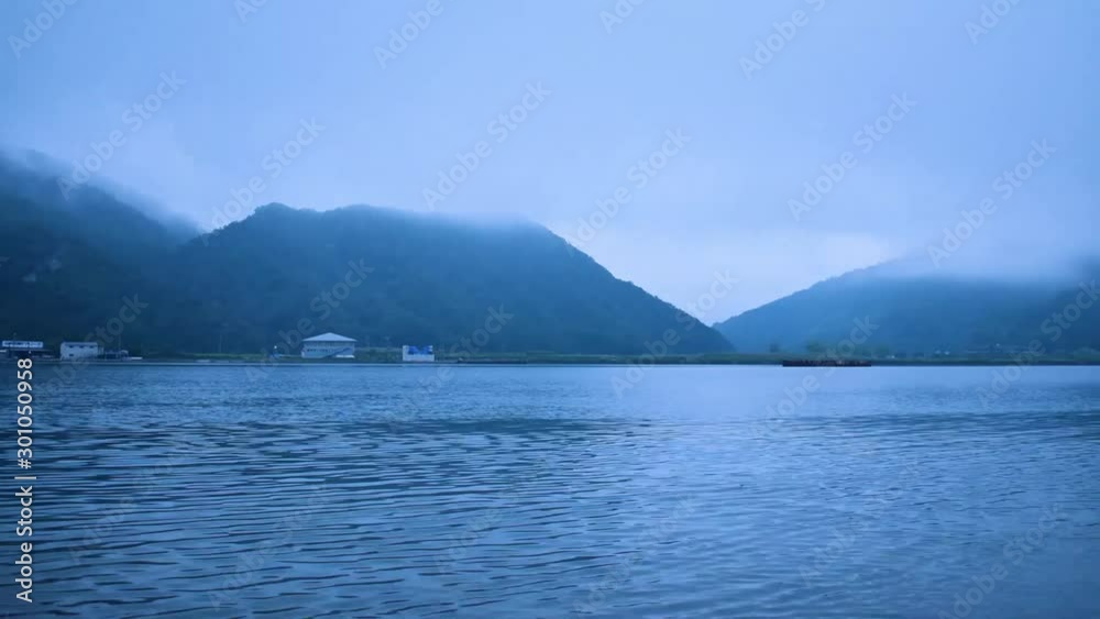Early morning lake timelapse with clouds rolling over mountains in Kinosaki-onsen, Japan Early morning lake timelapse with clouds rolling over mountains in Kinosaki-onsen, Japan