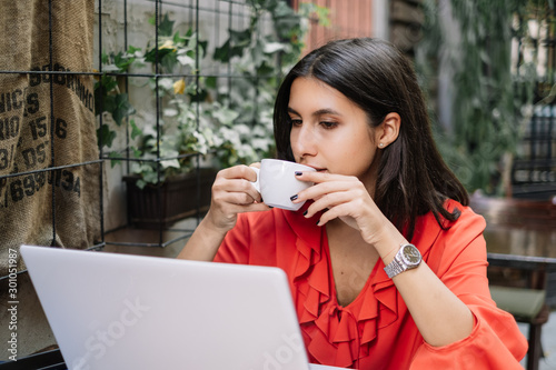 Close-up view of woman drinking coffee while working