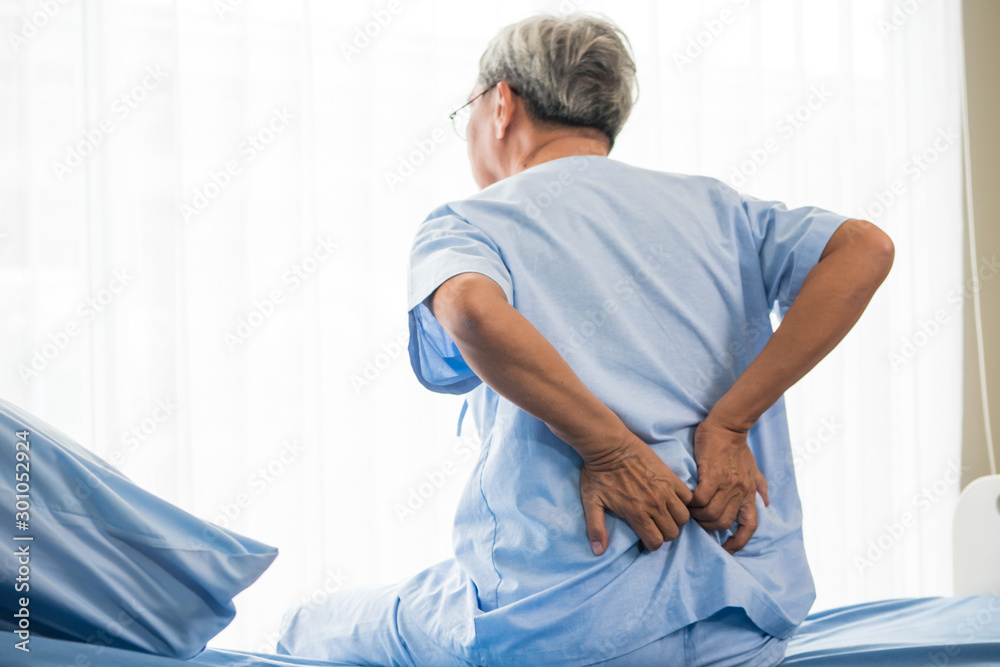 Senior male patient having back ache on hospital bed Senior male patient having back ache on hospital bed