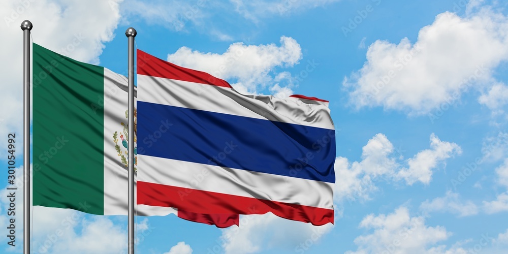 Mexico and Thailand flag waving in the wind against white cloudy blue sky together. Diplomacy concept, international relations.