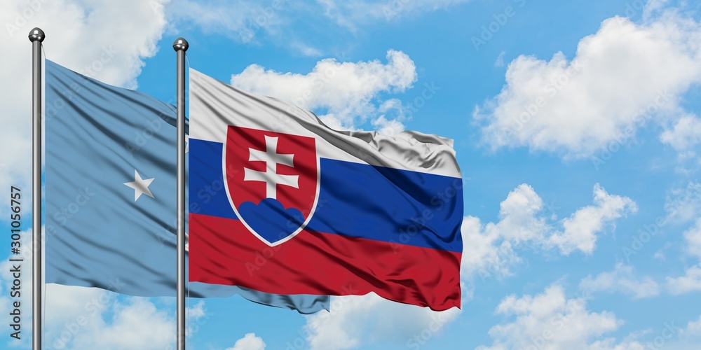 Micronesia and Slovakia flag waving in the wind against white cloudy blue sky together. Diplomacy concept, international relations.