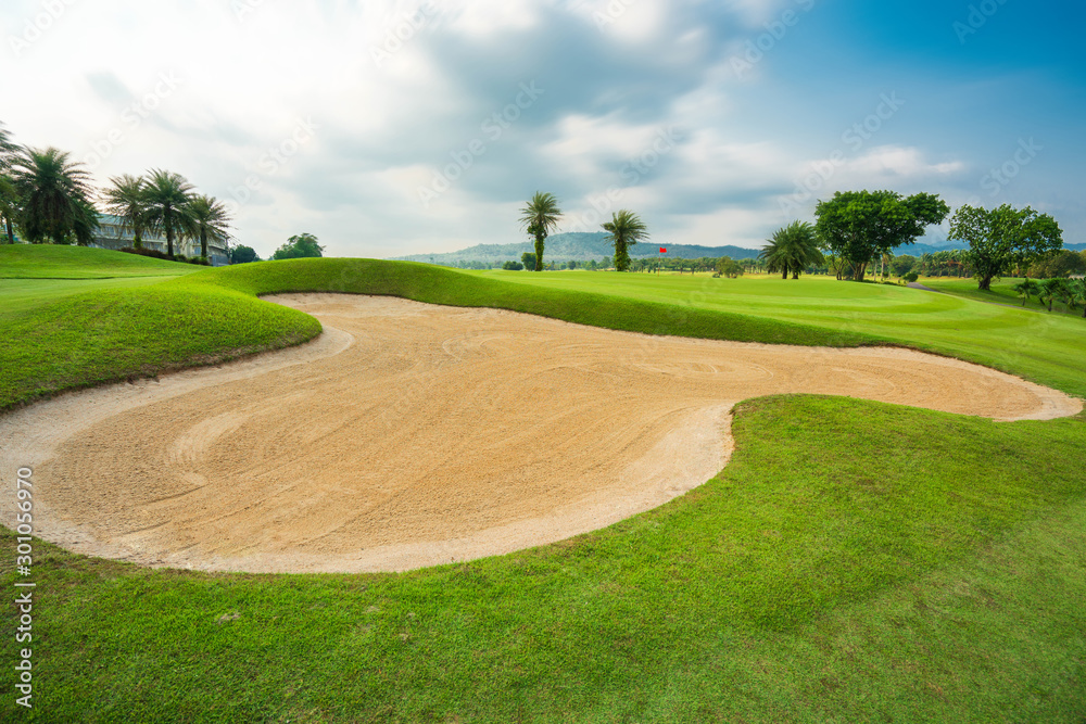 Sand bunker on the golf course with a mountain and tee as a background.