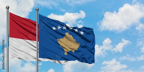 Monaco and Kosovo flag waving in the wind against white cloudy blue sky together. Diplomacy concept, international relations.