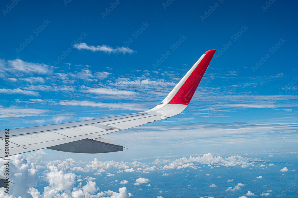 Fototapeta premium wing of an airplane flying above the clouds