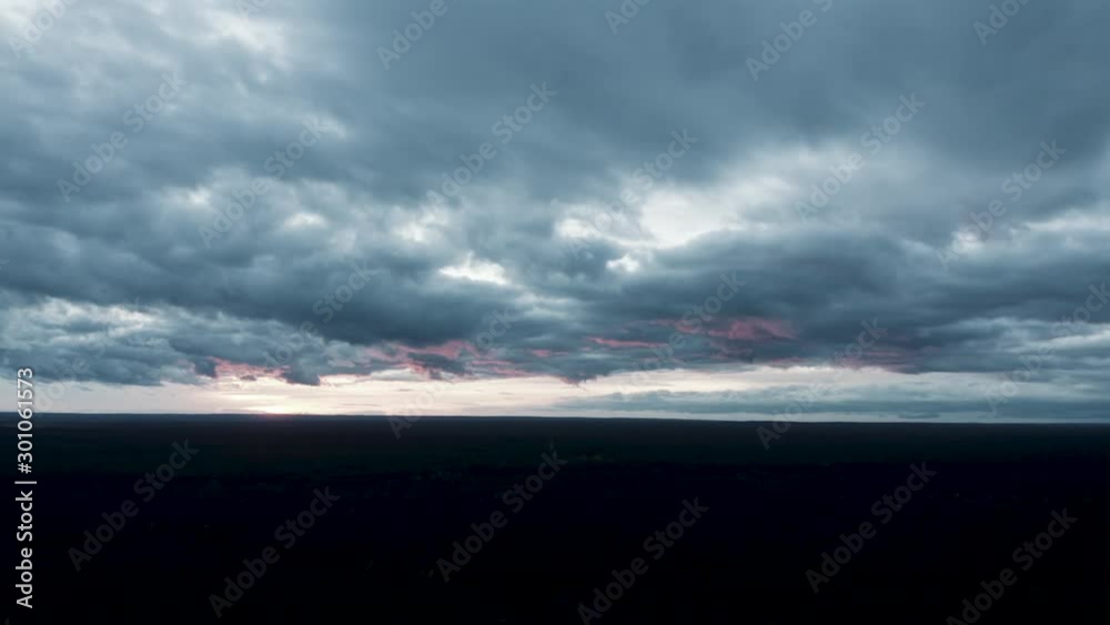 An epic aerial shot towards the sunset with an aesthetic cloudy sky on an autumn day.